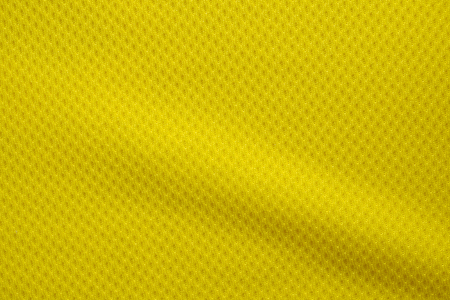 Yellow color football jersey clothing fabric texture sports wear background, close upの写真素材