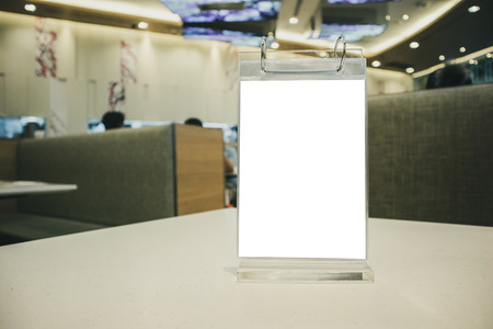 Mockup empty white label menu frame on table with cafe restaurant interior backgroundの写真素材