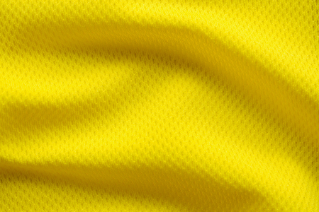 Yellow color football jersey clothing fabric texture sports wear background, close upの写真素材