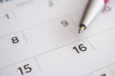 Calendar page with pen point at 16th dateの写真素材
