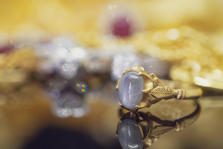 Vintage gold Jewelry blue sapphire rings with reflection on black backgroundの写真素材