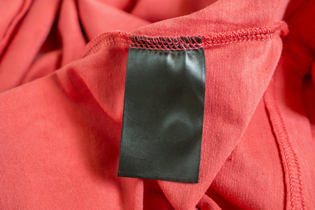 blank black color clothing label on red t shirtの写真素材