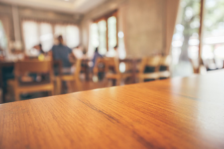 Restaurant interior with customer and wood table blur abstract background with bokeh light