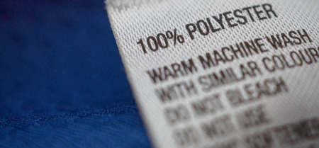 Polyester clothing label with laundry care instructions tag on blue shirt jerseyの写真素材