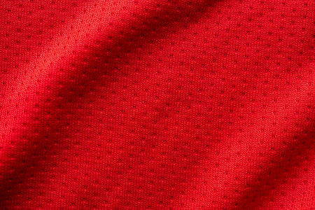 Red fabric sport clothing football jersey with air mesh texture backgroundの写真素材