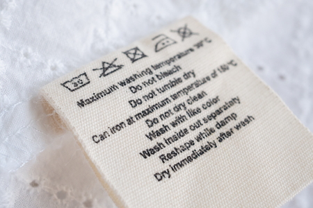 laundry care washing instructions clothes label on fabric texture backgroundの写真素材