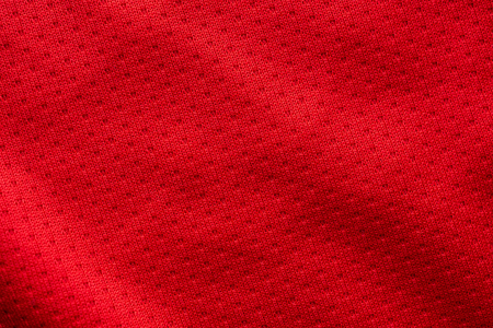 Red fabric sport clothing football jersey with air mesh texture backgroundの写真素材
