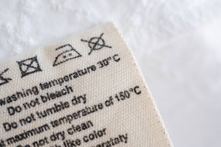 laundry care washing instructions clothes label on fabric texture backgroundの写真素材