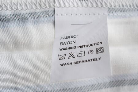 White laundry care washing instructions clothes label on rayon shirt