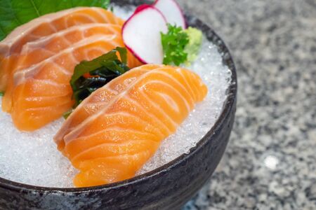 salmon sashimi on ice in black bowl japanese foodの写真素材