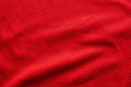 Red fabric sport clothing football jersey with air mesh texture backgroundの写真素材