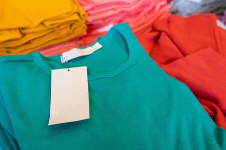 Blank white clothes tag on new shirt in store