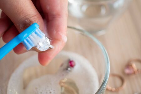Jeweller hand cleaning and polishing vintage jewelry diamond ring closeup