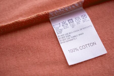 White laundry care washing instructions clothes label on cotton shirtの写真素材