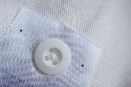 laundry care clothing label with button on cotton shirt