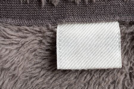 Blank white laundry care clothing label on fur texture background
