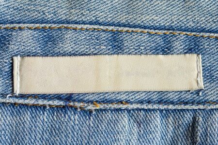 Blank white laundry care clothing label on denim jeans texture backgroundの写真素材