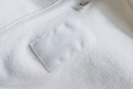 Blank white clothes label on new cotton shirt backgroundの写真素材