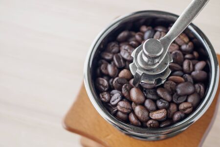 Vintage manual coffee grinder with roasted coffee beans