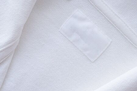 Blank white clothes label on new shirt background