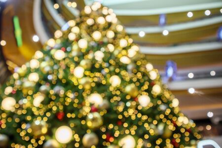 Abstract christmas holiday with festive gold bokeh light on tree blurred backgroundの写真素材