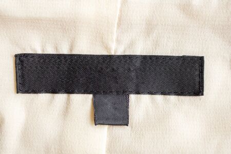 Blank black laundry care clothing label on fabric textureの写真素材