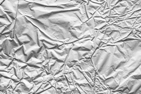 Shiny metal silver gray foil crumpled texture backgroundの写真素材