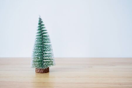 christmas tree on wood table with white wall background