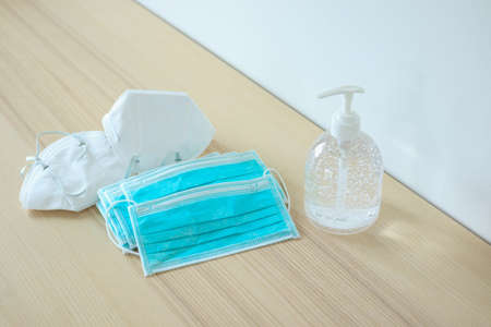 Medical face mask with alcohol sanitizer gel hand wash on wood table for covid-19 Coronavirus...