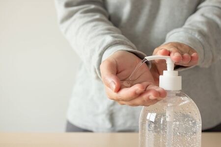 Woman using alcohol sanitizer gel rub for cleaning hand COVID-19 corona virus prevention conceptの写真素材