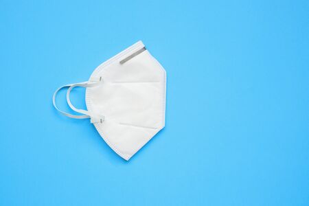 KN95 face mask on blue background protection against pm 2.5 polution and COVID-19 coronavirus. Healthcare and medical conceptの写真素材