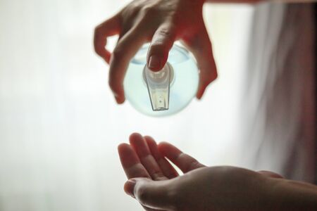 Woman using alcohol sanitizer gel rub for cleaning hand COVID-19 corona virus prevention conceptの写真素材