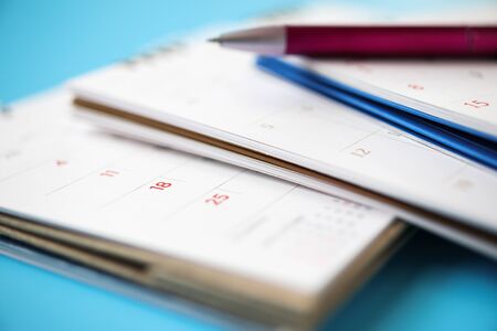 calendar page with pen close up on blue background business planning appointment meeting conceptの写真素材