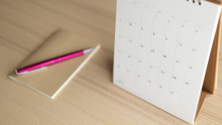 calendar page close up on wood table background with pen and notebook business planning appointment...
