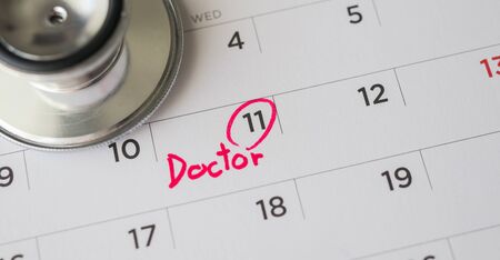 Stethoscope with calendar page date background doctor appointment medical conceptの写真素材