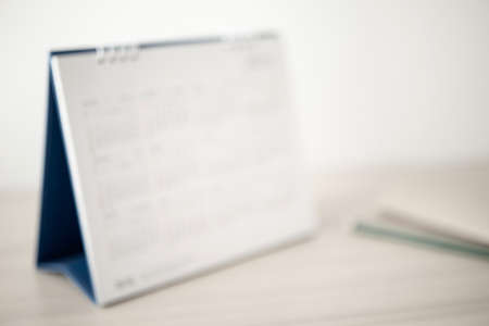 Blur calendar page close up on wood table background business planning appointment meeting conceptの写真素材