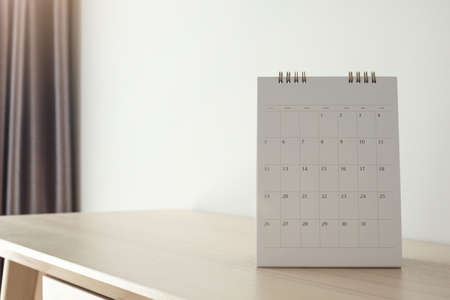 Calendar page close up on wood table with white wall backgroundの写真素材