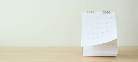 Calendar page flipping sheet on wood table background business schedule planning appointment meeting conceptの写真素材
