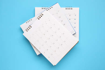 calendar page close up on blue background business planning appointment meeting concept