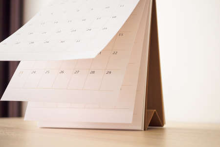Calendar page flipping sheet on wood table background business schedule planning appointment meeting...