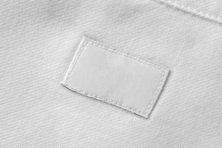 White blank laundry care clothes label on cotton shirt backgroundの写真素材