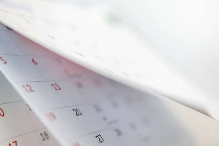 Calendar page flipping sheet close up on office table interior background business schedule planning...