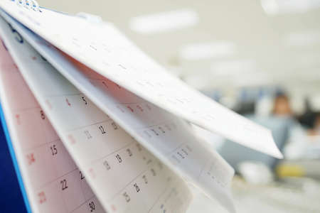 Calendar page flipping sheet close up on office table interior background business schedule planning appointment meeting conceptの写真素材