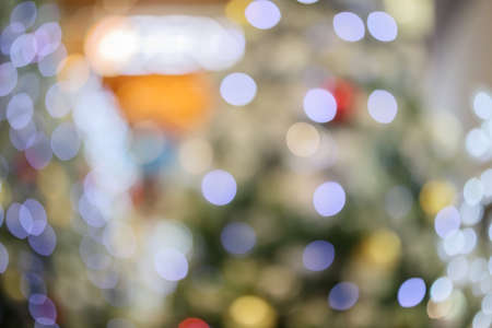 Abstract christmas holiday with festive gold bokeh light on tree blurred backgroundの写真素材
