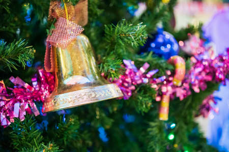 Decorated Christmas bell baubles on fir tree New Year holidays background