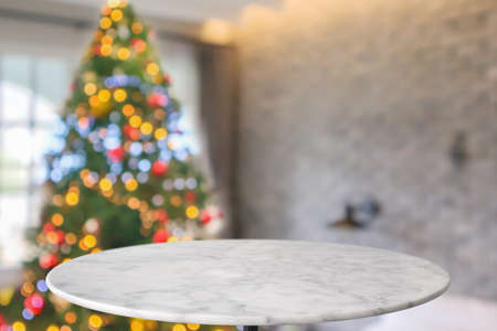 Empty round marble table top with blurred Christmas tree with bokeh light backgroundの写真素材