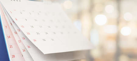 Close up white paper desk calendar with blurred bokeh background appointment and business meeting conceptの写真素材