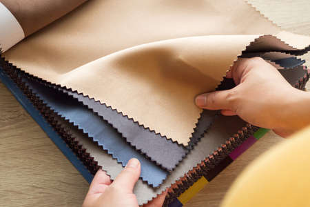 female designer with fabric color samples choosing textile for curtains
