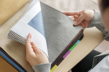 Female designer with fabric color samples choosing textile for curtainsの写真素材