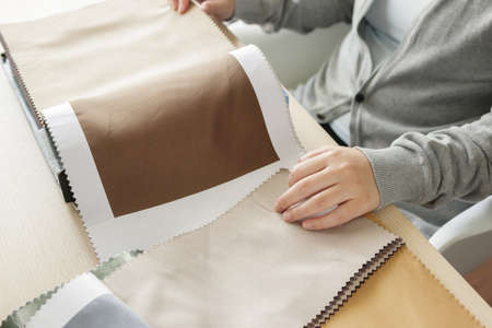 Female designer with fabric color samples choosing textile for curtainsの写真素材